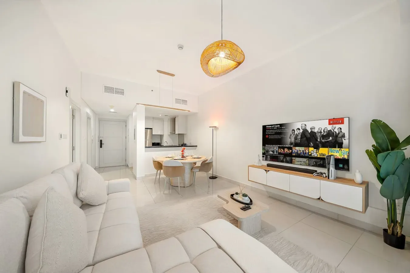 Una sala luminosa con asientos, un comedor y un televisor.