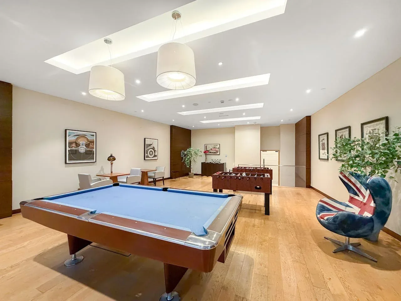 Una sala de juegos cuenta con una mesa de billar y una mesa de futbolín.