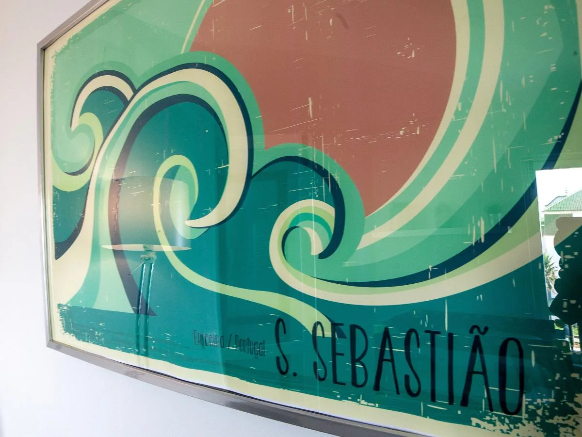 A framed graphic print depicts stylized teal and green waves.