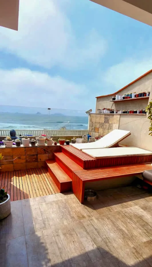 A seaside terrace with tiered wooden seating and views of the ocean.