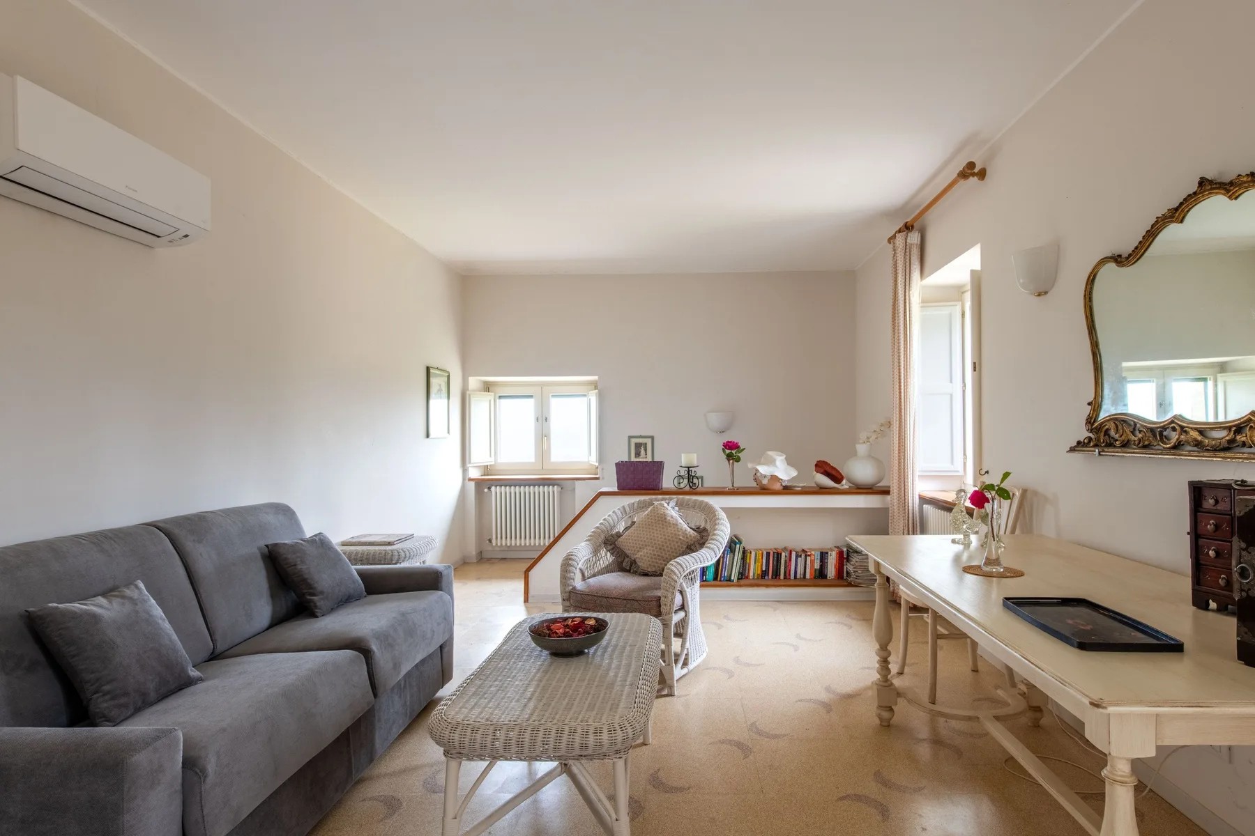 Una sala de estar luminosa con asientos, una mesa de centro y una mesa de comedor.