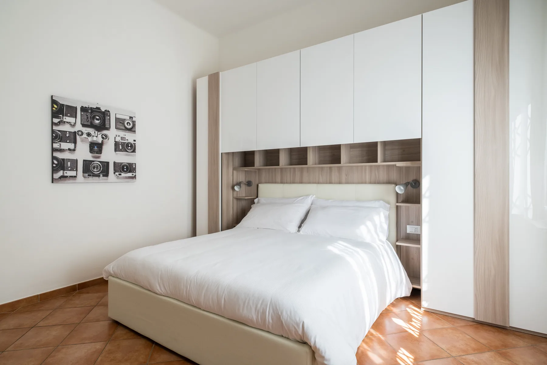 Un dormitorio con una cama bien tendida y armarios empotrados.