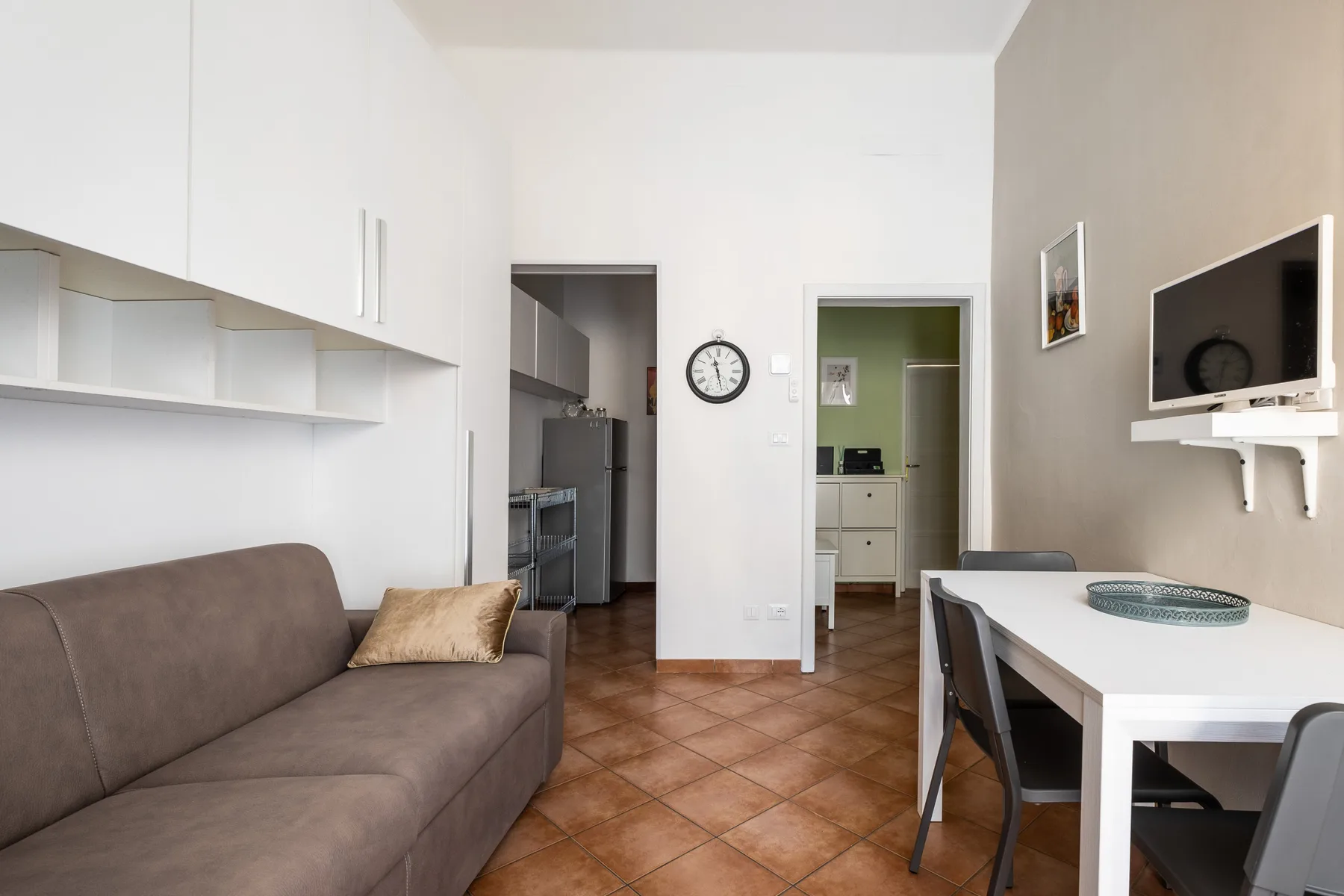 A living and dining area with seating, a table, and a television.
