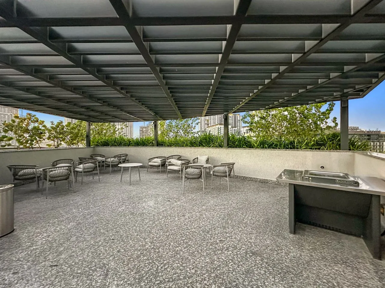 Una terraza exterior cubierta con asientos y una encimera integrada.