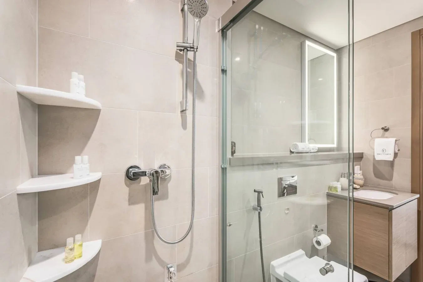 Un baño alicatado con ducha de vidrio y mueble de lavabo.
