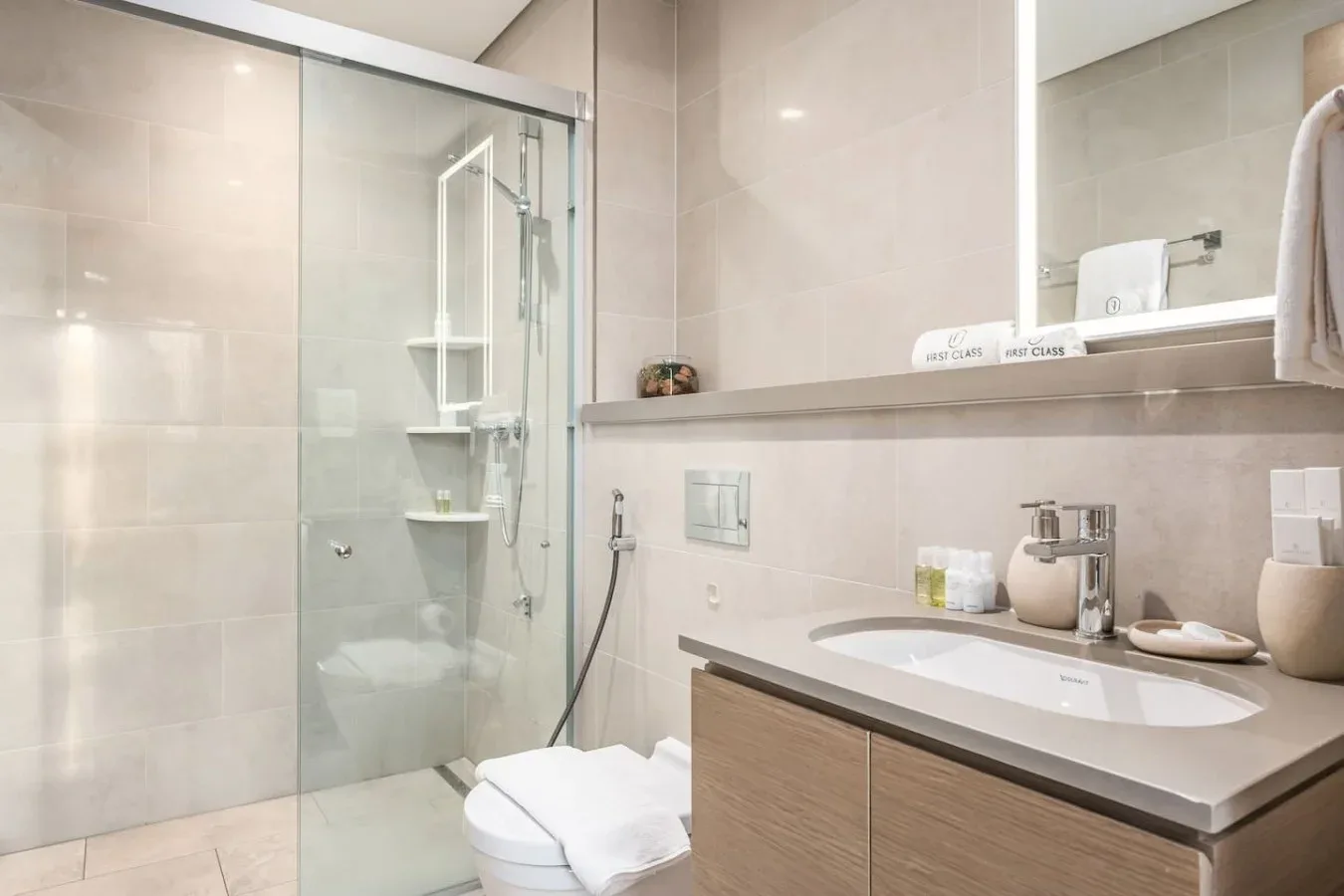 Un baño moderno con una ducha de vidrio y un amplio lavabo.