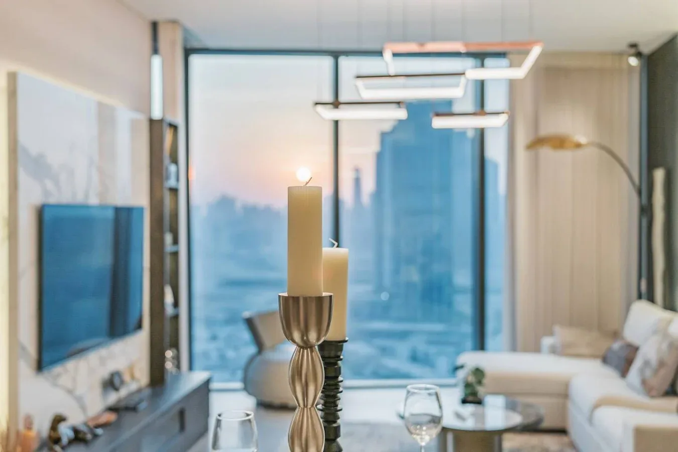 Una sala de estar moderna con asientos y grandes ventanales con vistas a la ciudad.