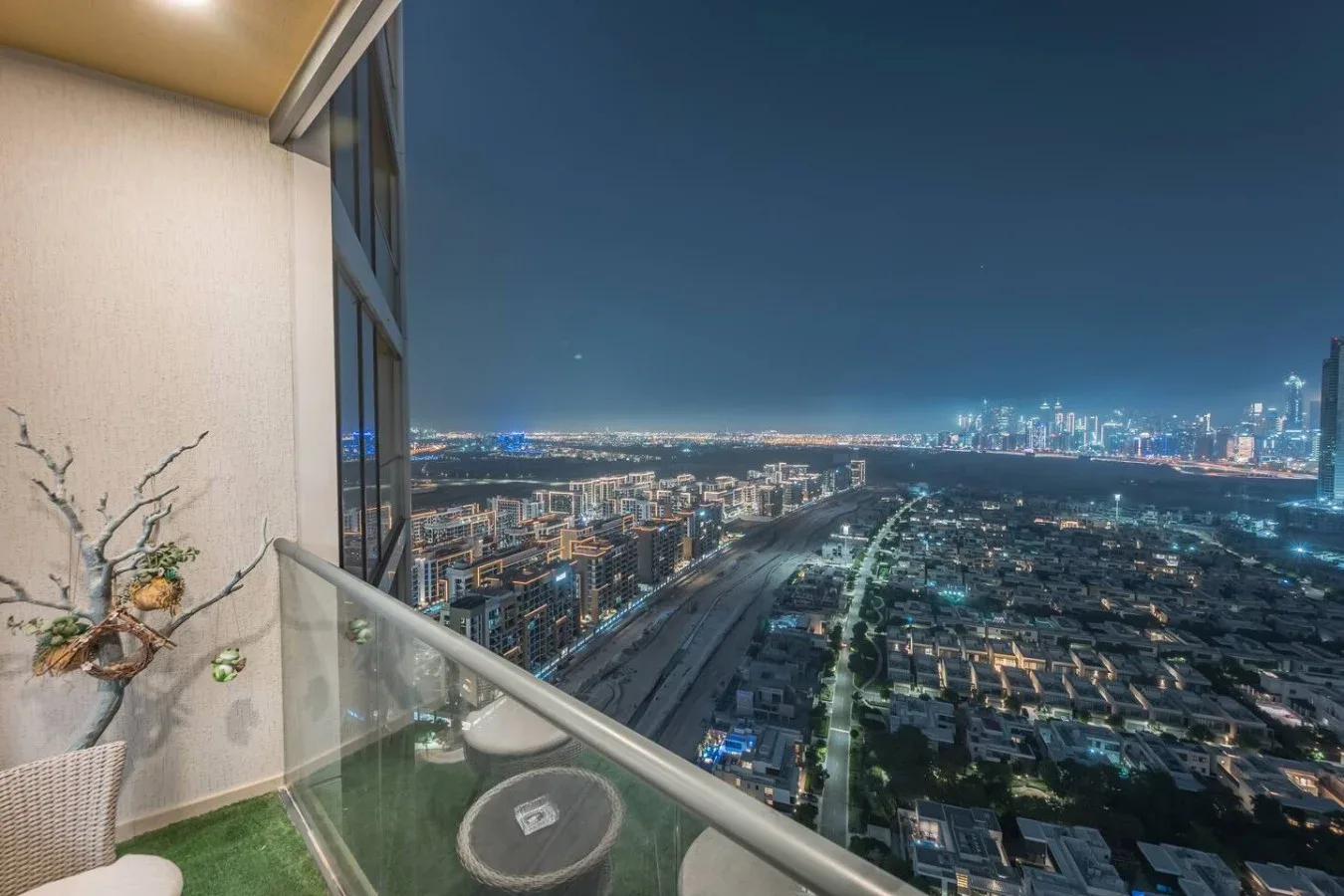 Un balcón ofrece vistas de un horizonte urbano iluminado por la noche.