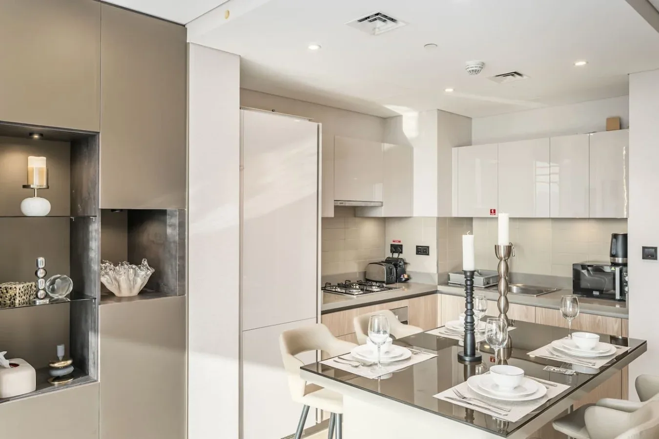 Una cocina moderna con gabinetes claros y una mesa puesta para comer.