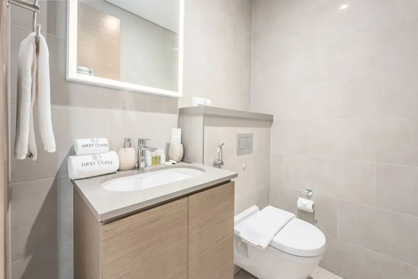 Un baño con lavabo, espejo e inodoro.