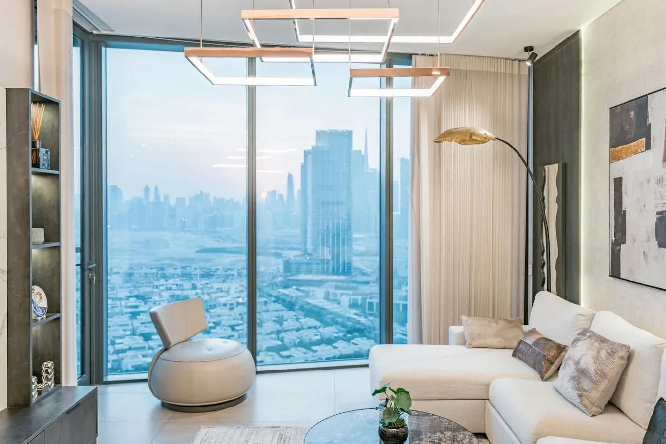 Una sala de estar con asientos junto a ventanales con vistas a la ciudad.