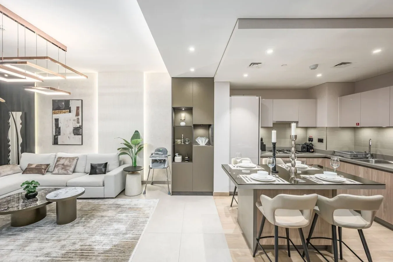 Una sala de estar y cocina de planta abierta con una isla y asientos.
