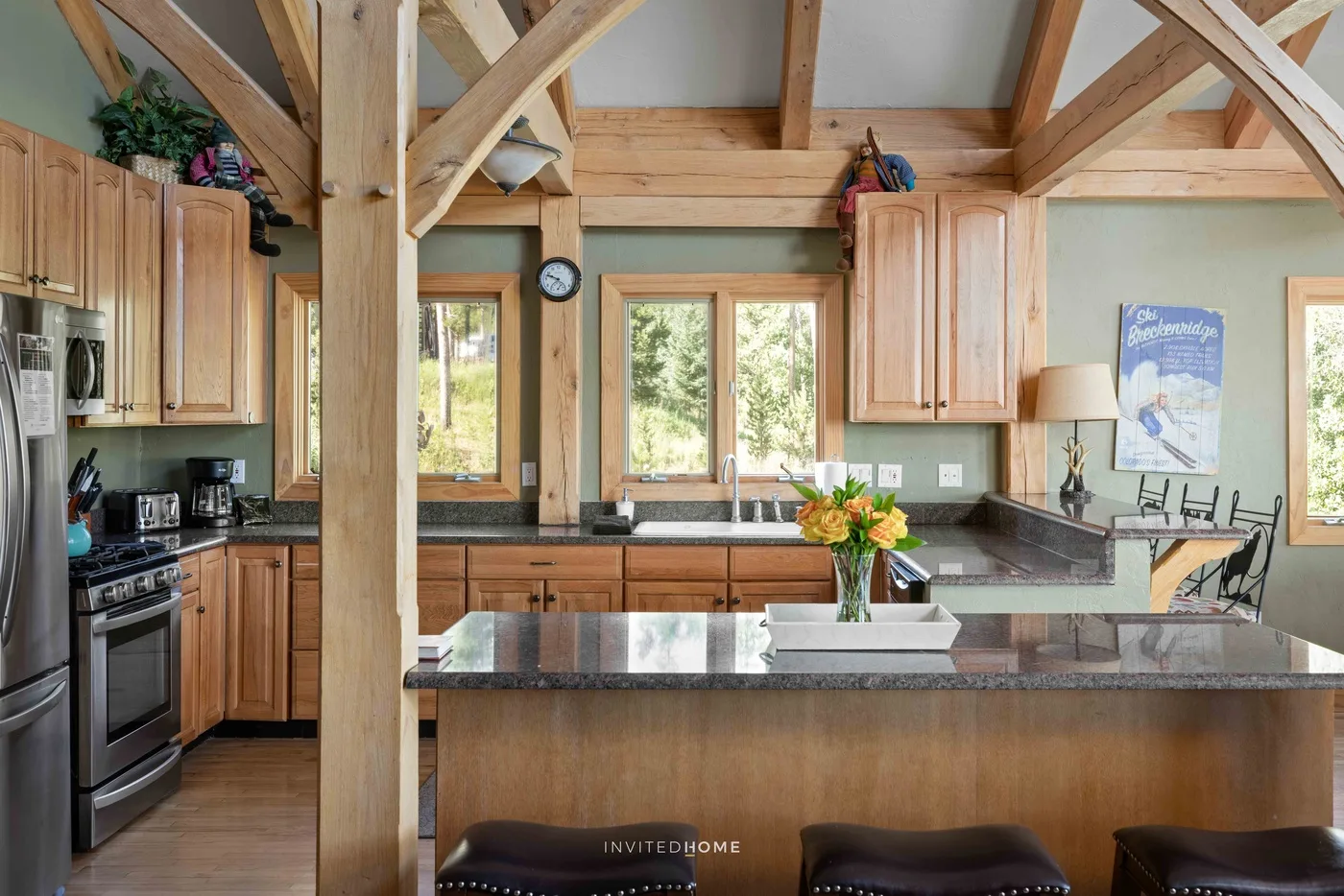 A kitchen with wooden cabinetry, dark countertops, and a central island.