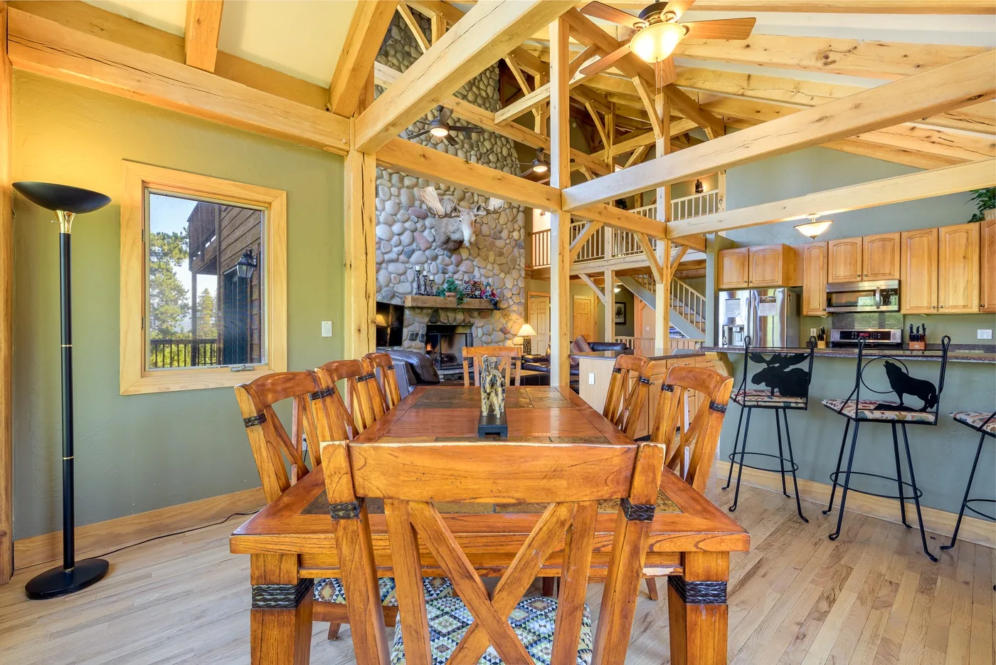 A dining area with a long wooden table beneath exposed timber beams.