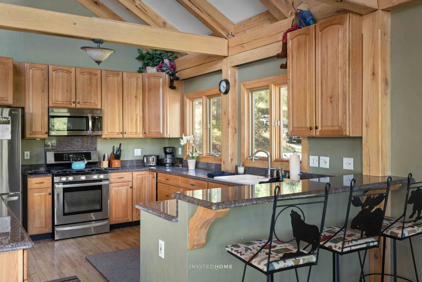 A spacious kitchen with wooden cabinets, a central island, and a breakfast bar.