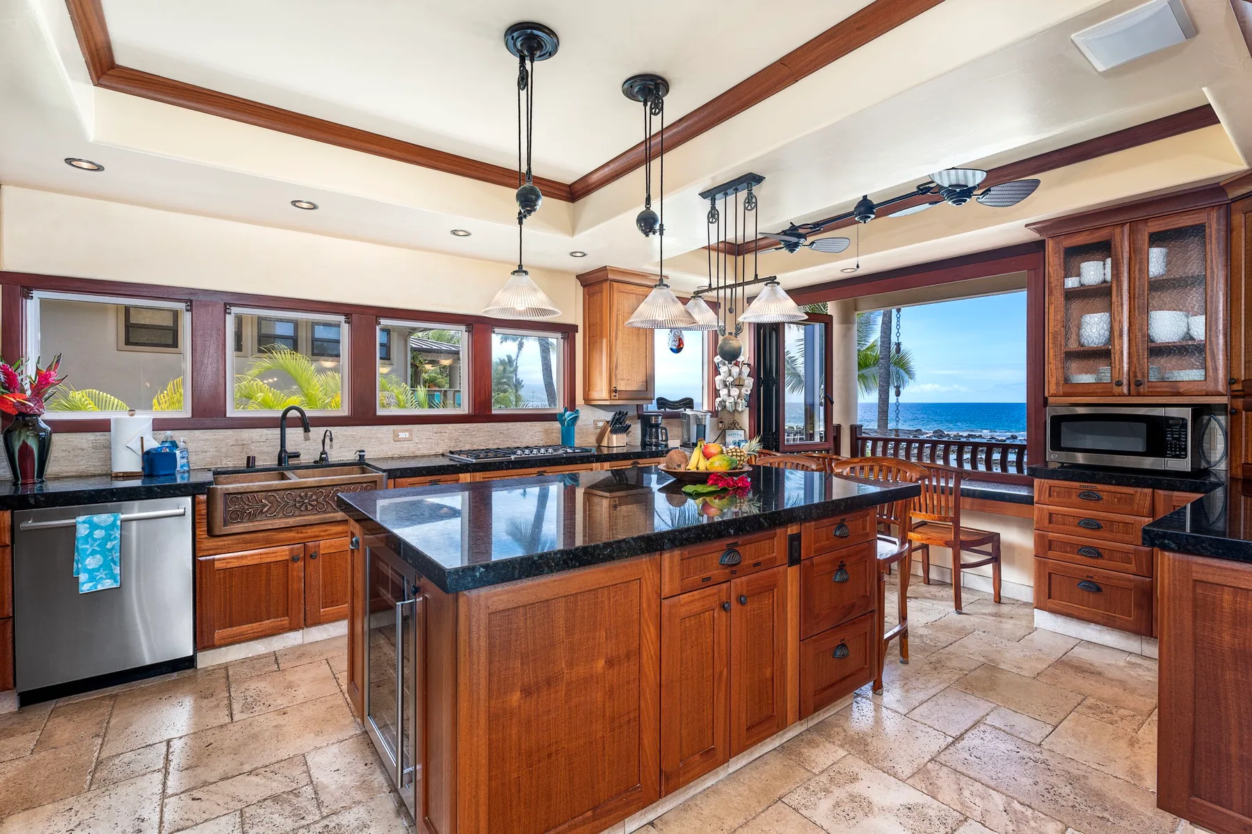 A spacious kitchen with a central island and windows overlooking the ocean.