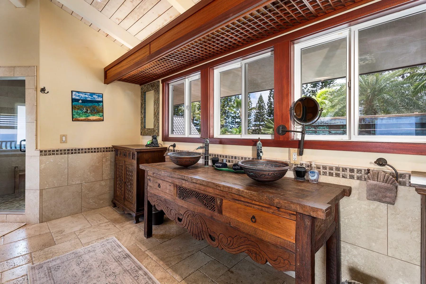 A bathroom vanity with two sinks sits beneath a row of windows.