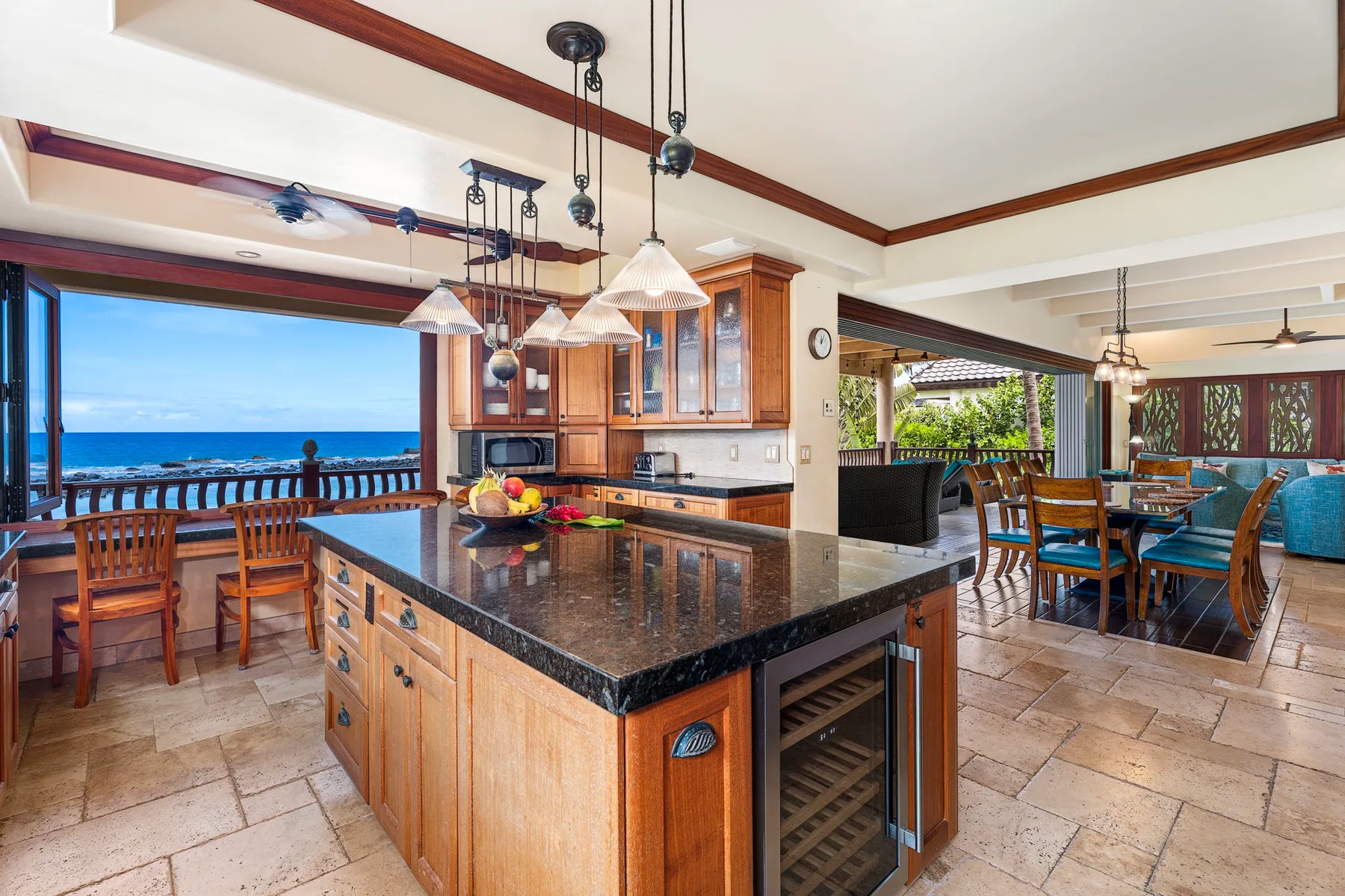 An open kitchen and dining area features a central island and ocean views.
