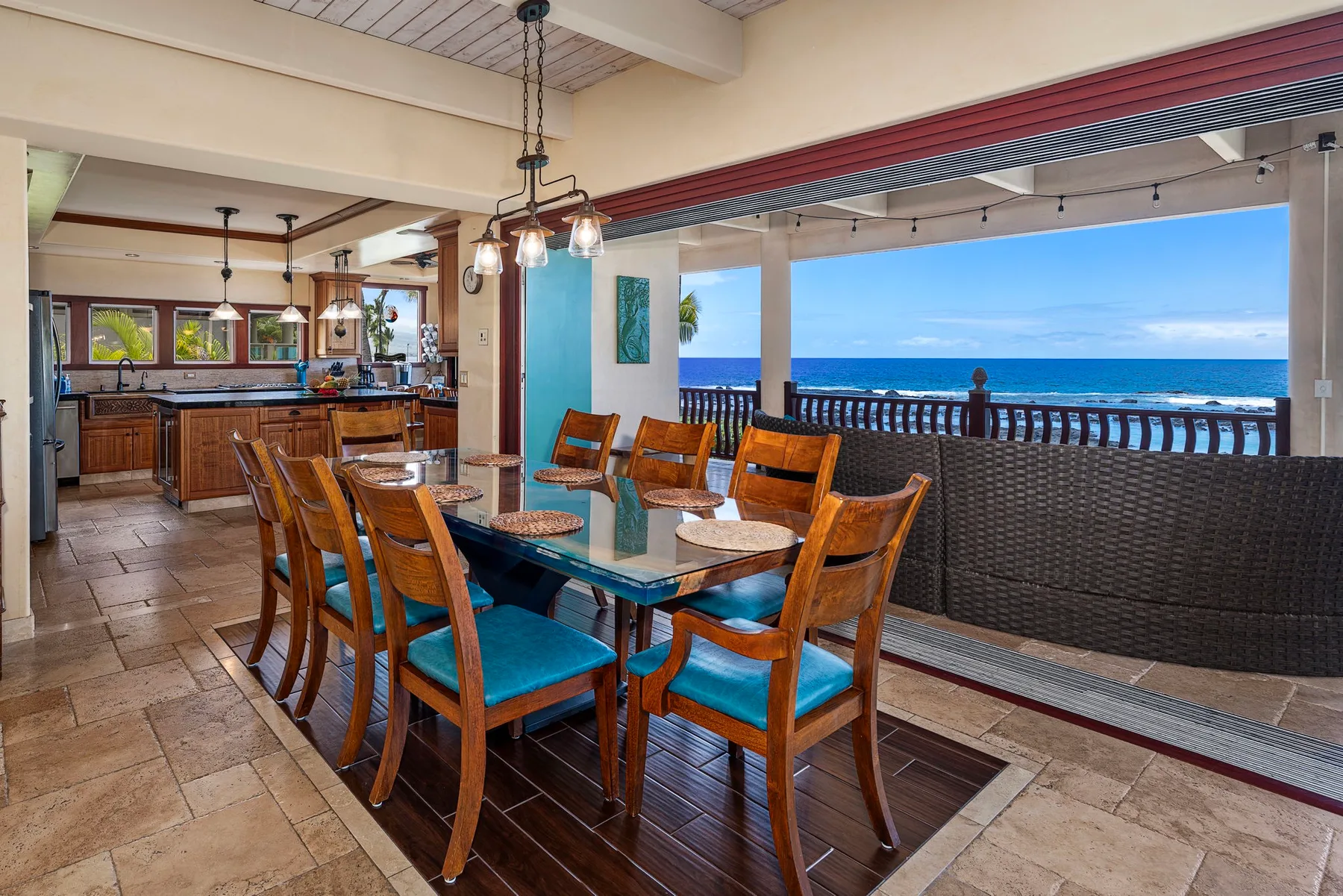 A dining area opens onto a covered patio overlooking the ocean.
