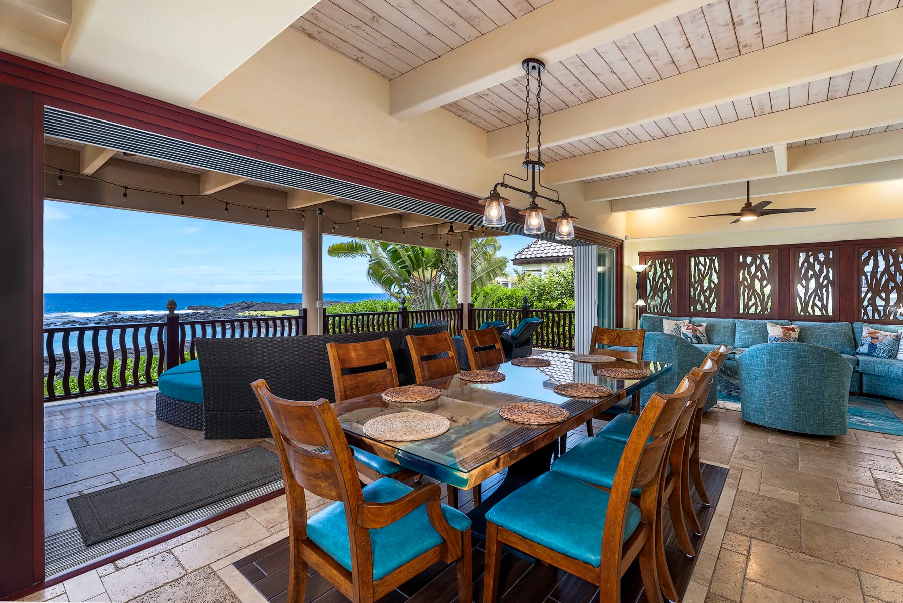 An open-air dining area with a wooden table and ocean views.
