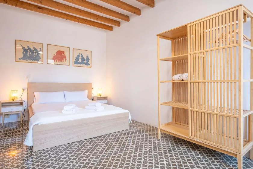 Un dormitorio con una cama y un separador de listones de madera.