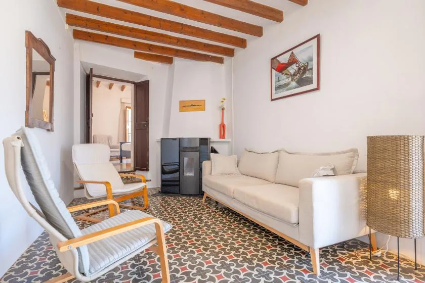 Una sala de estar con un sofá, un sillón y un suelo estampado.