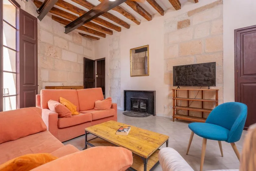 Una sala de estar con asientos alrededor de una mesa de centro de madera y una chimenea.