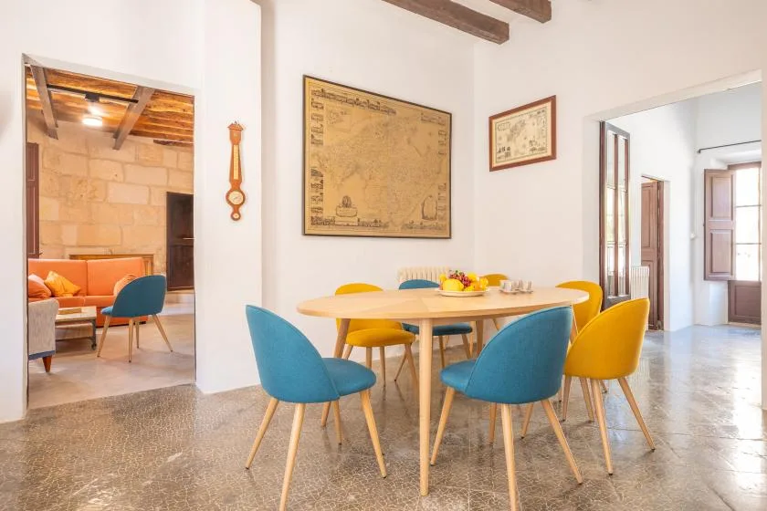 Comedor con una mesa redonda y asientos de colores.
