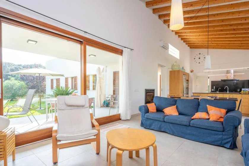 Una luminosa sala de estar da a un patio a través de grandes puertas de vidrio.
