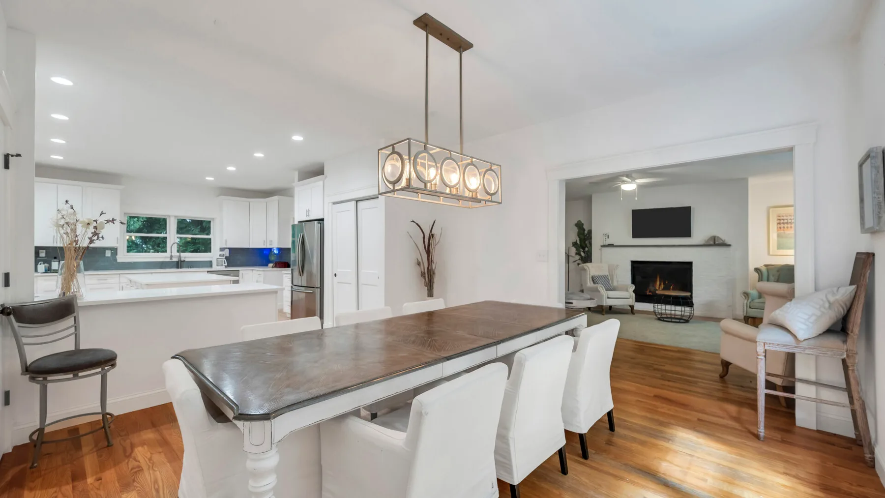 An open-plan kitchen and dining area with a long table and seating.