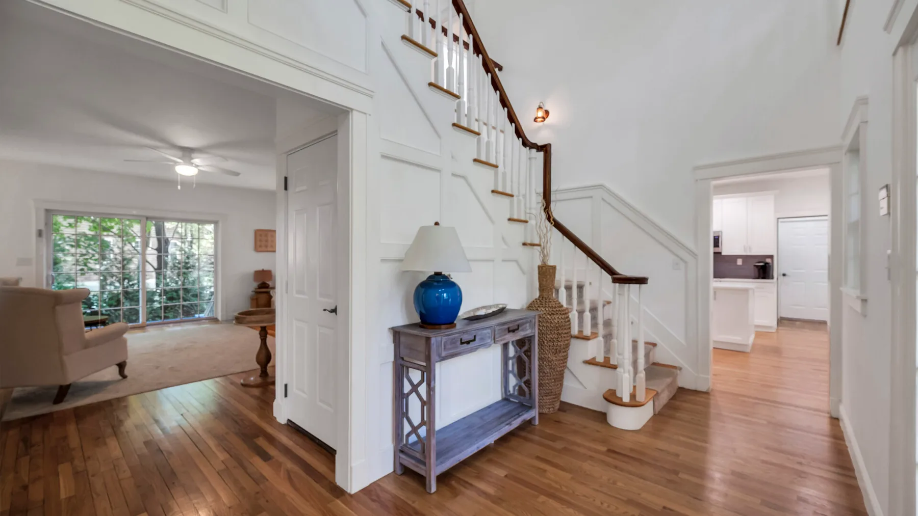 A bright entry hall with a staircase and a small console table.