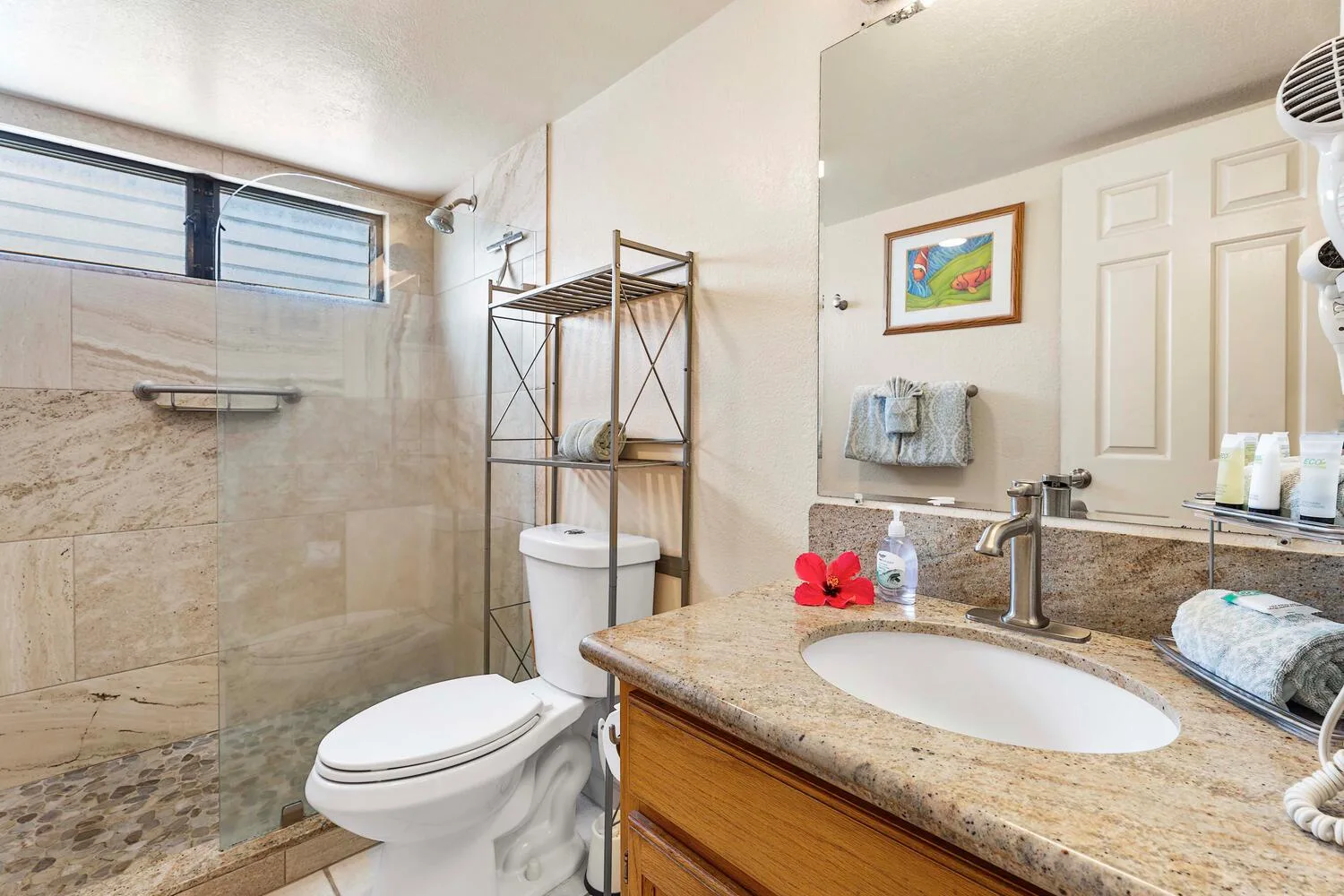 Un baño con ducha de vidrio, inodoro y lavabo con mueble.