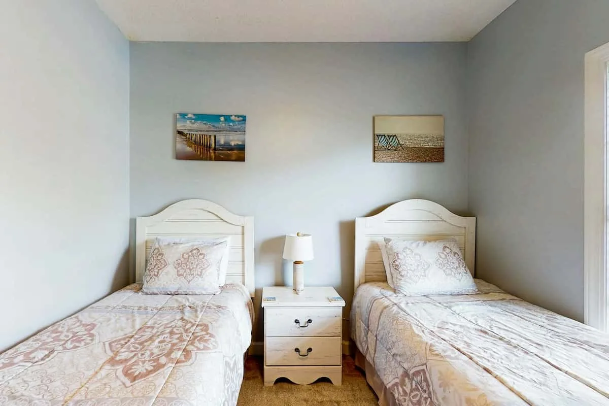 Un dormitorio con dos camas individuales y una mesita de noche entre ellas.