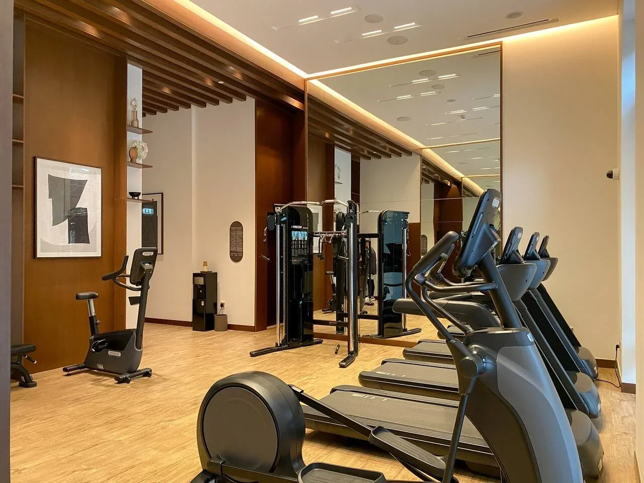 Un gimnasio con máquinas de ejercicio y equipos cardiovasculares.