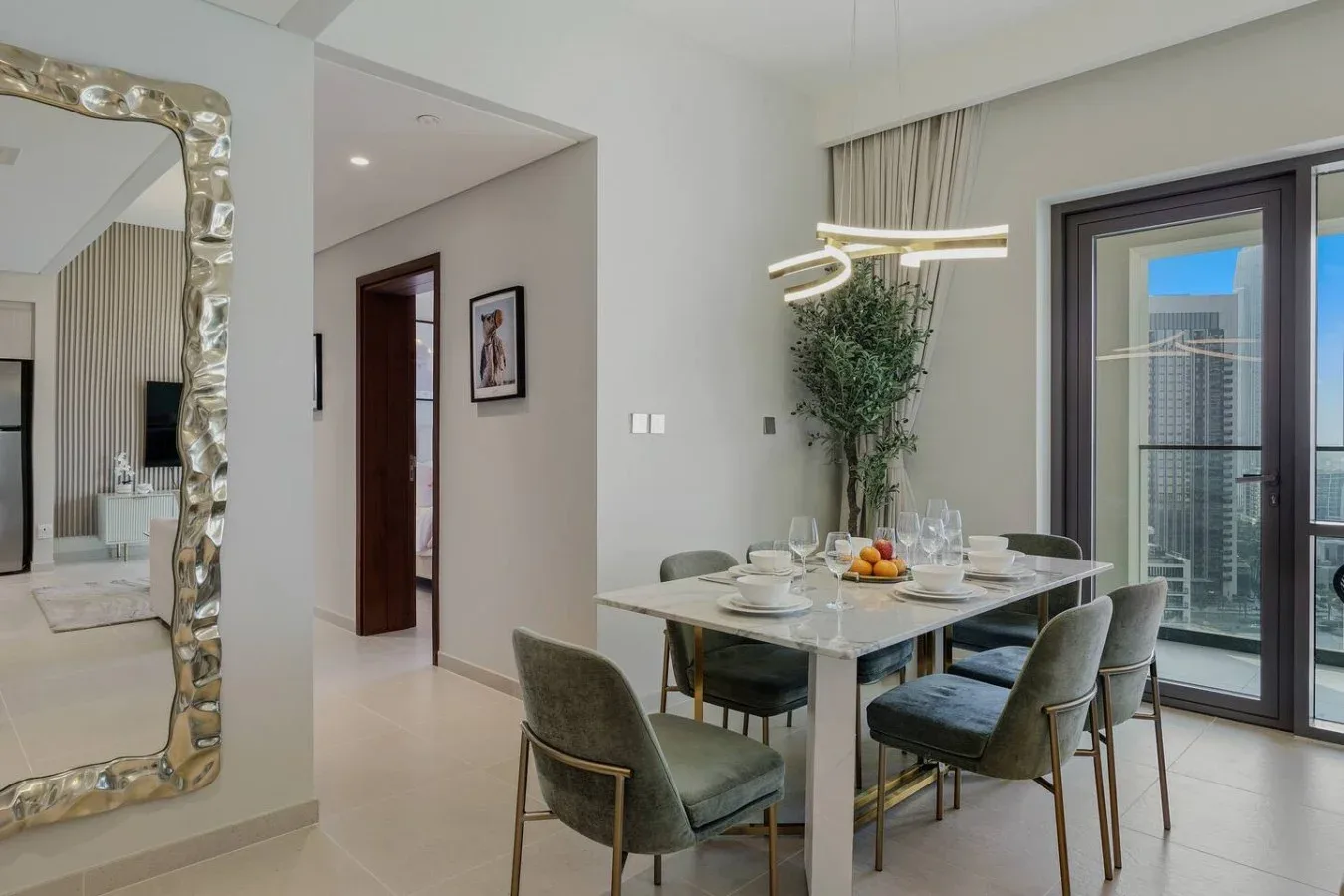 Comedor con la mesa puesta, asientos tapizados y una ventana amplia.