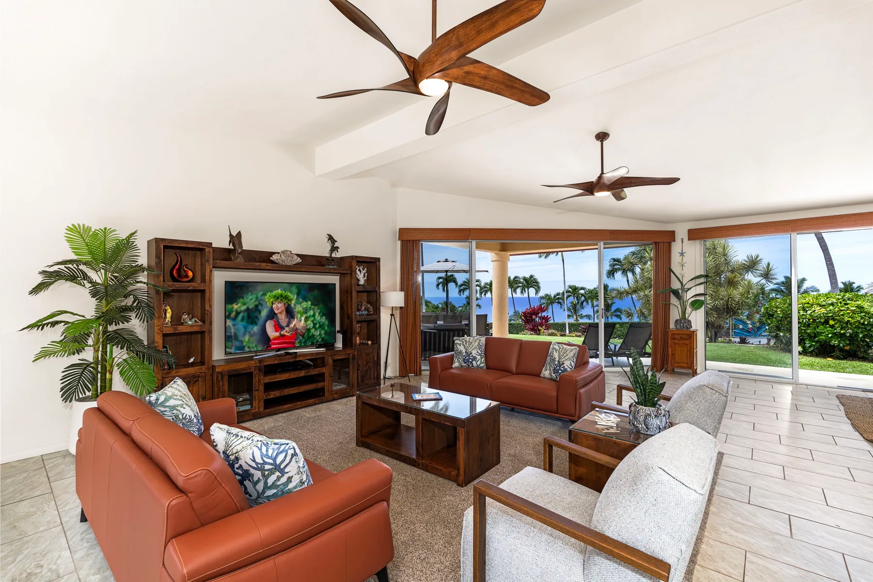 A bright living room has seating around a coffee table beside wide windows.