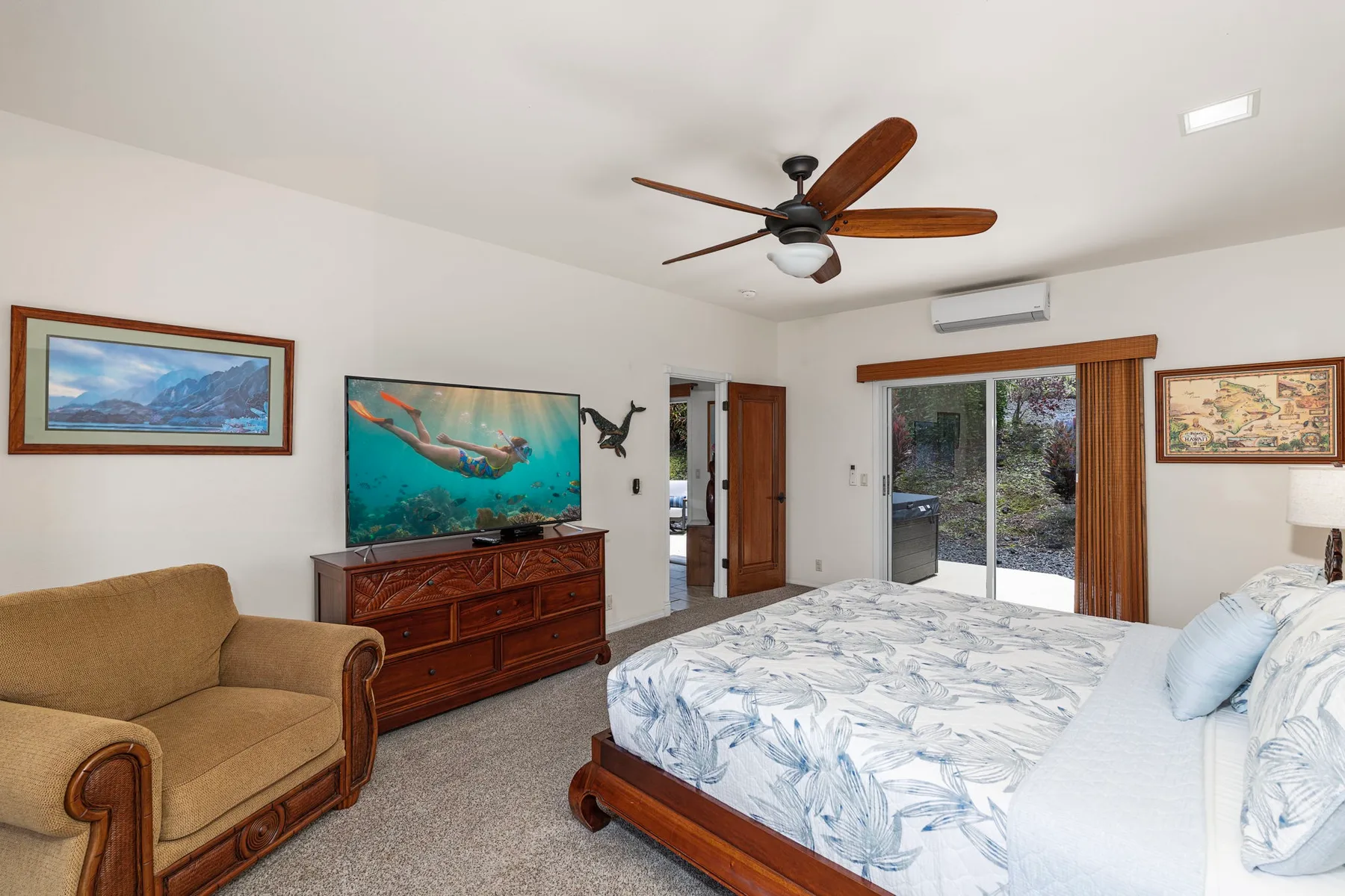 A bedroom with a bed, a ceiling fan, and a television on a dresser.