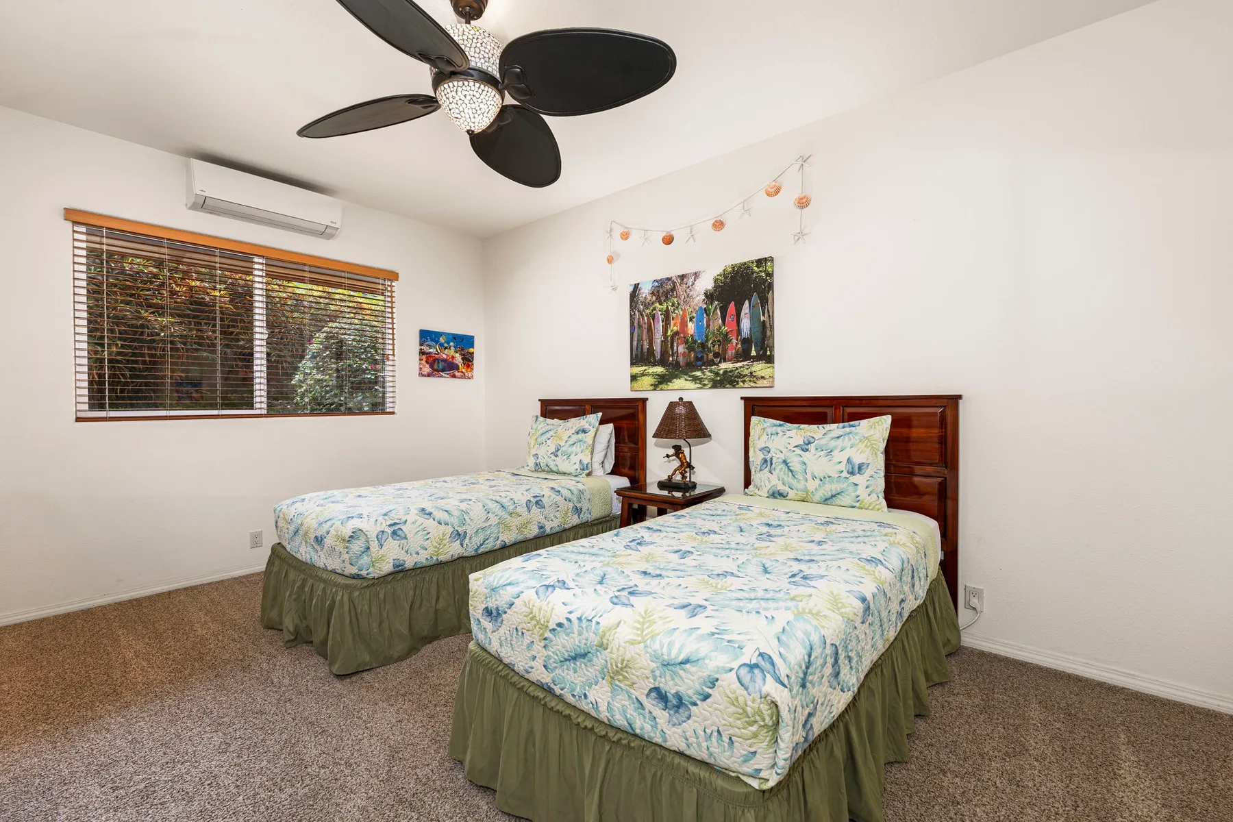A bedroom with two single beds and a ceiling fan.