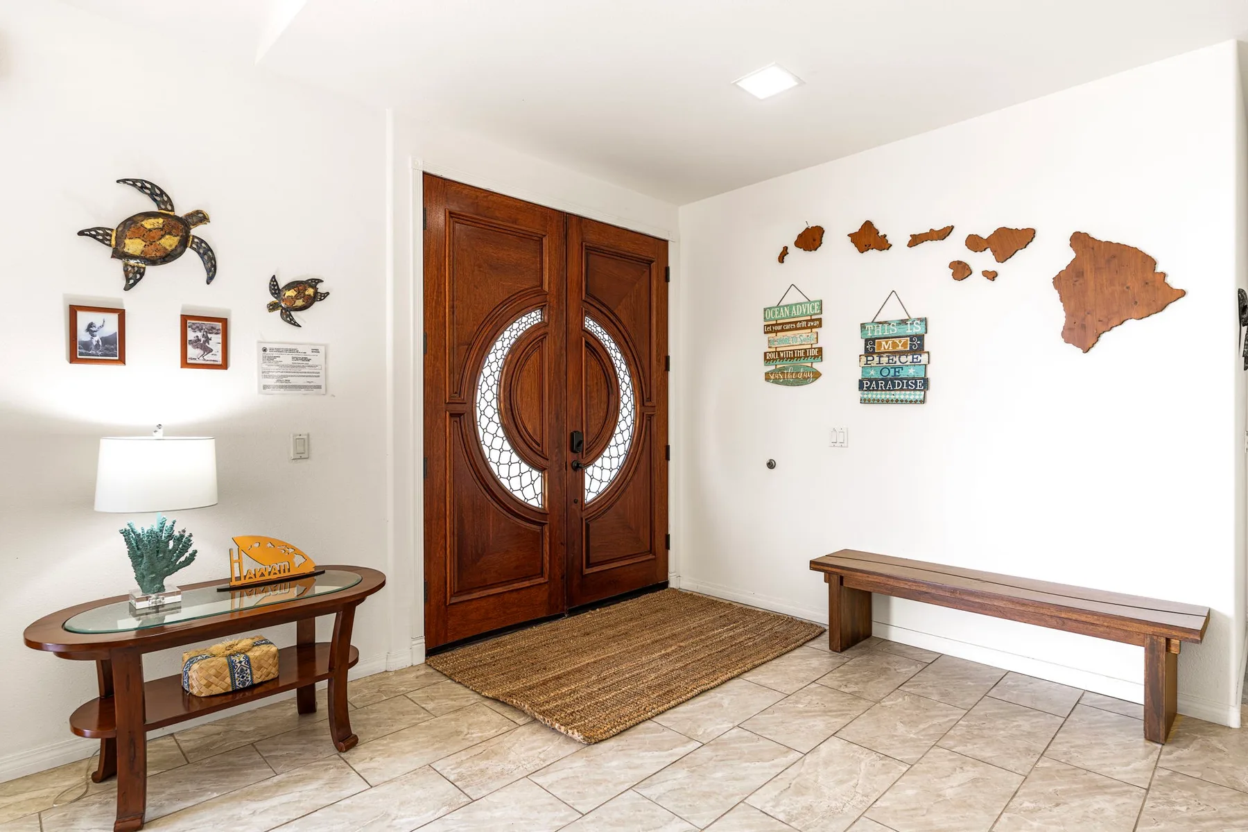 An entryway with an ornate wooden double door and a bench.