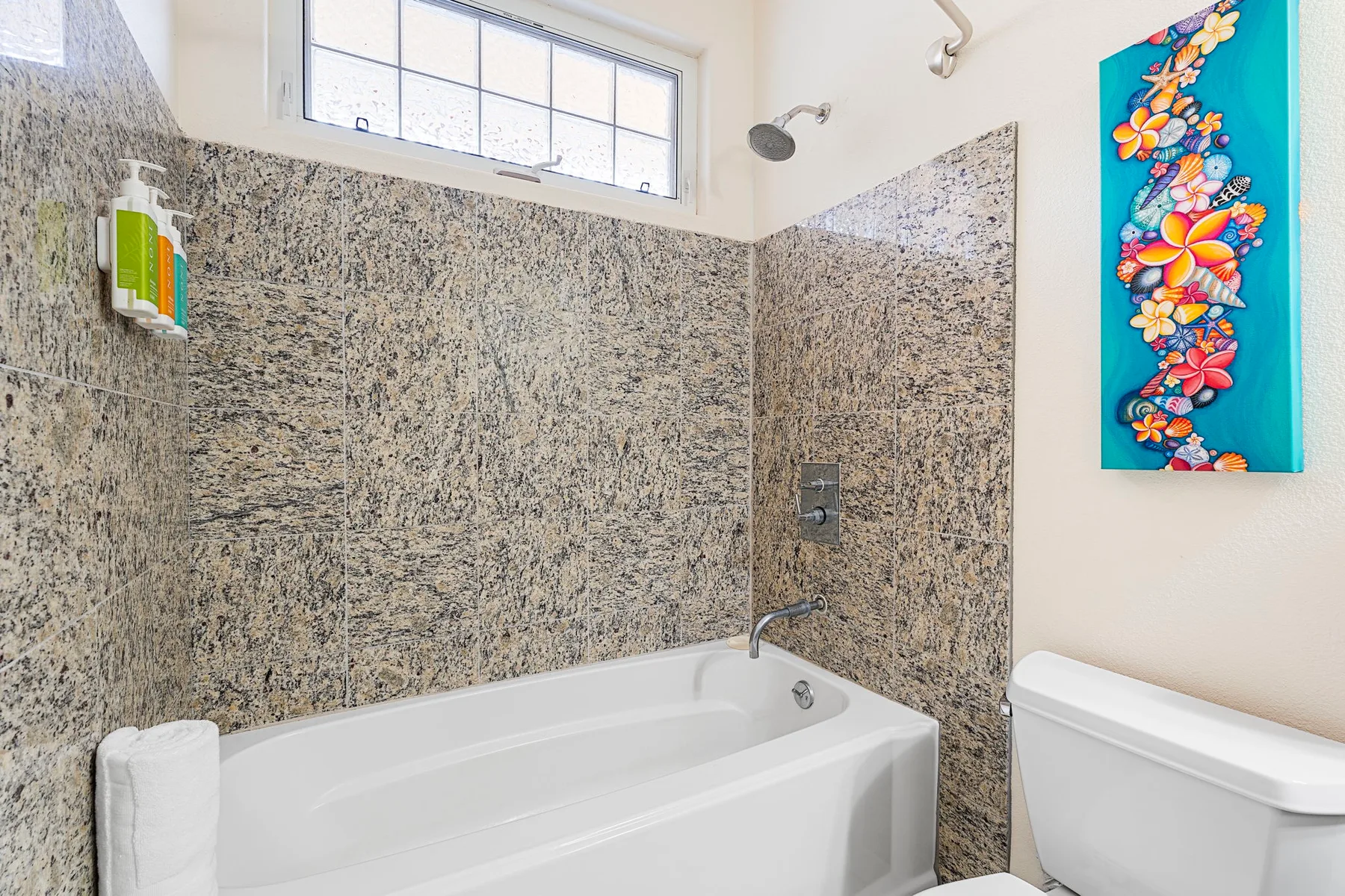A bathroom with a bathtub, shower, and toilet.