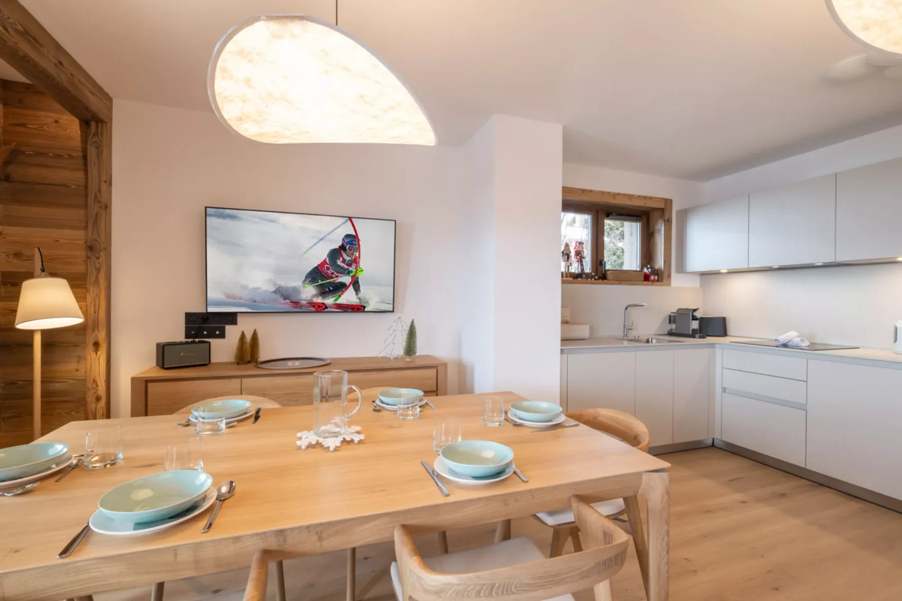 A dining area with a set table beside an open kitchen.