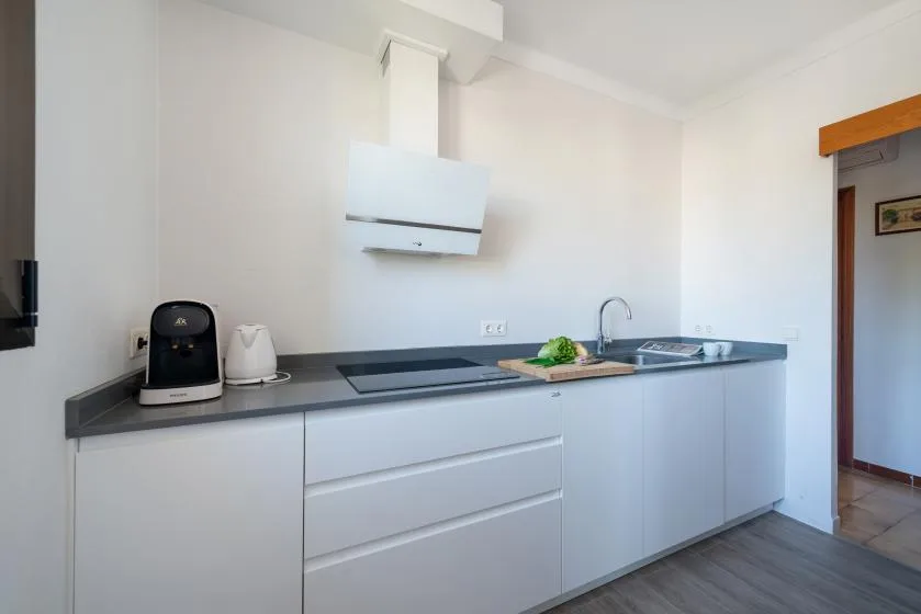 Una cocina luminosa con encimera, placa de cocina y fregadero.