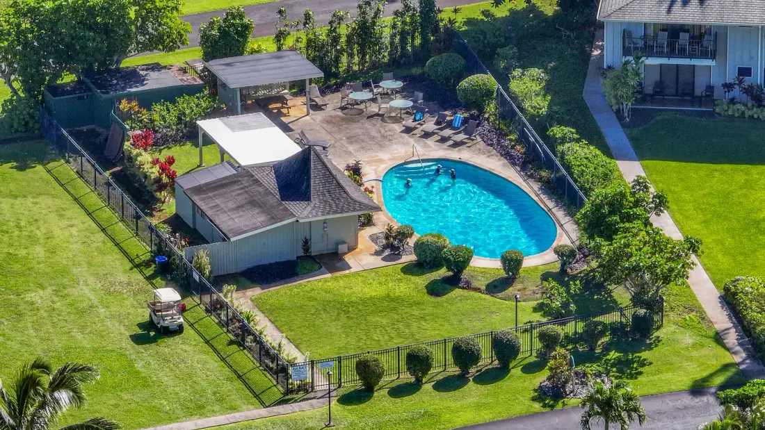 Vista aérea de una piscina cercada y jardines.