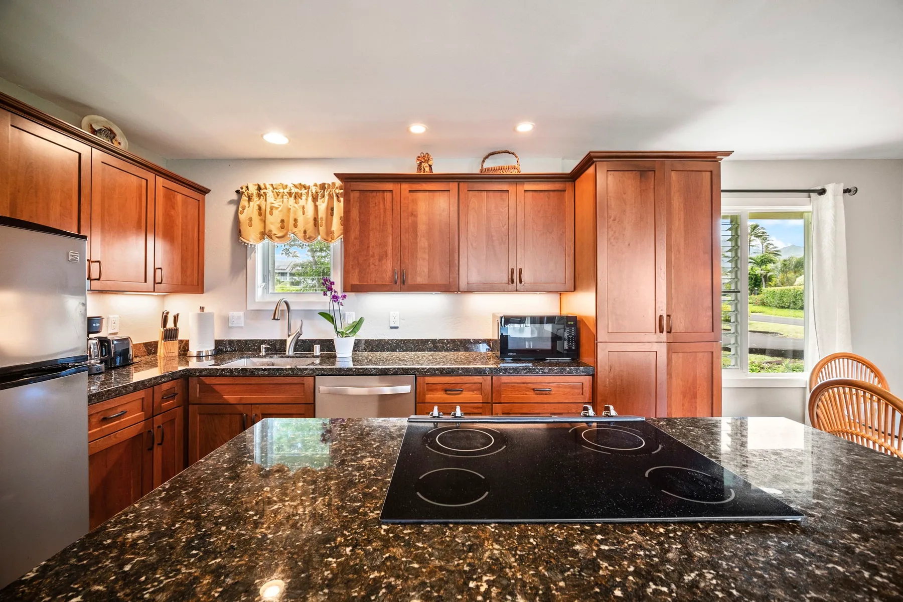 Una cocina con gabinetes de madera y una isla grande con una estufa.