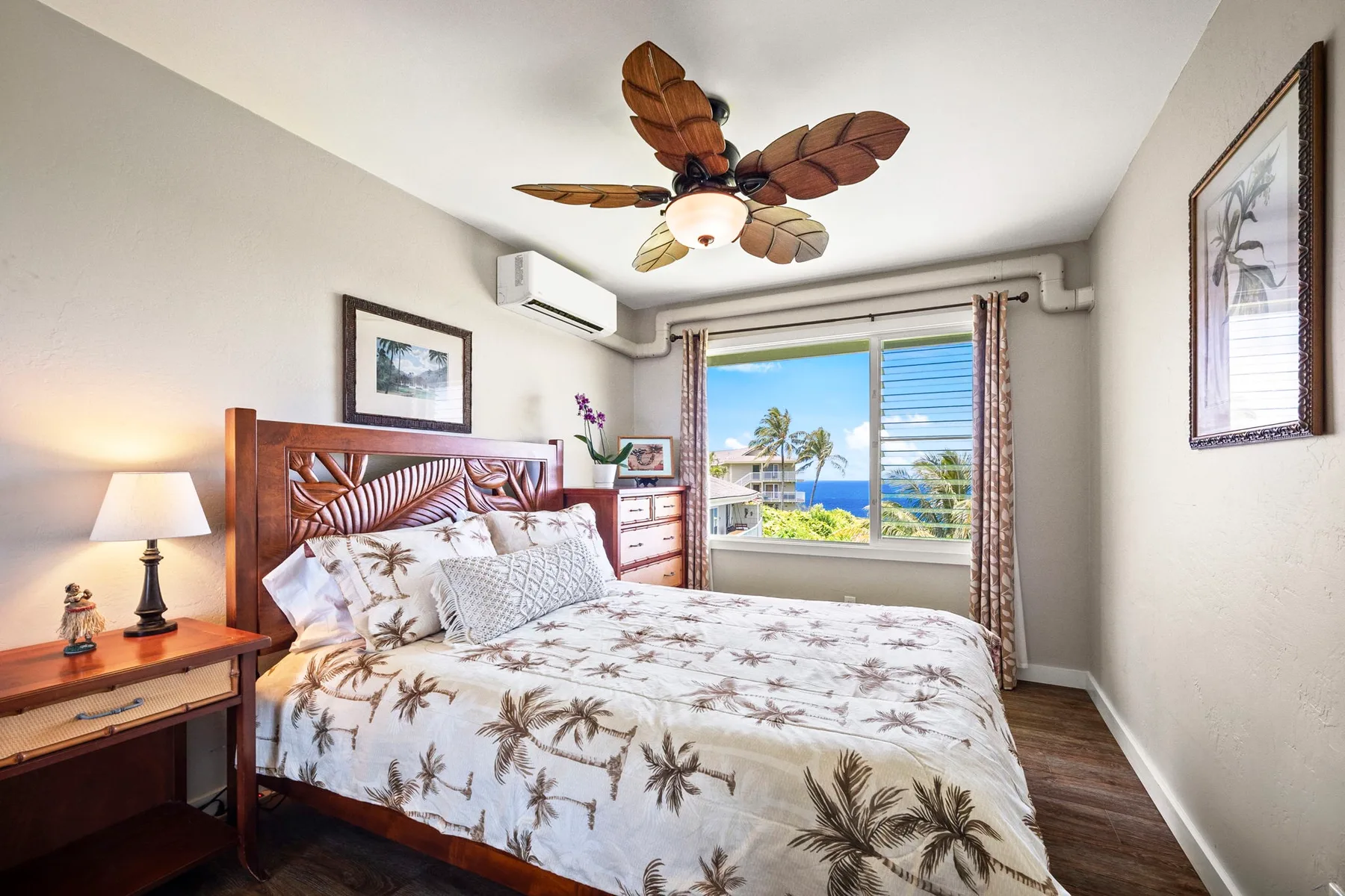 Un dormitorio con una cama bien hecha y una ventana con vistas al mar.