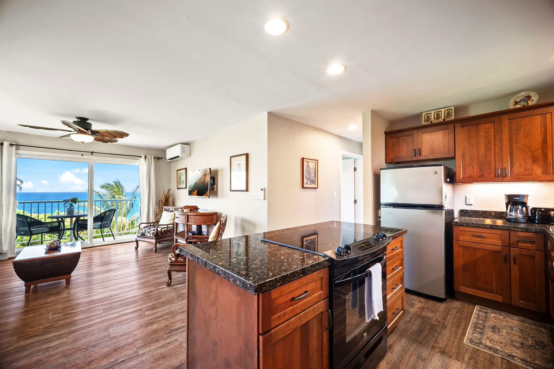 Cocina y comedor de planta abierta con una isla central y una puerta corrediza de vidrio.