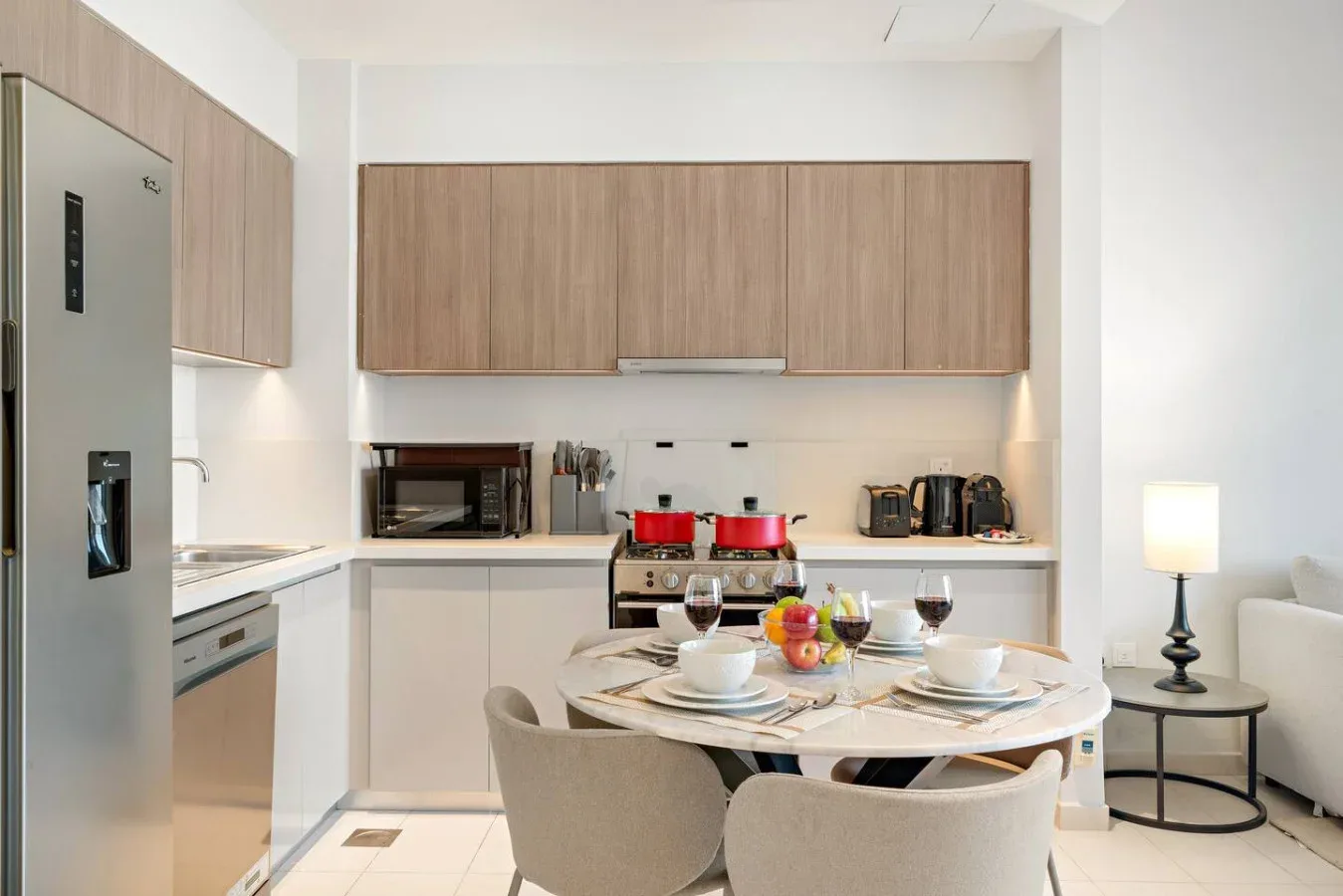 A modern kitchen and dining area with wood cabinets and a set dining table.