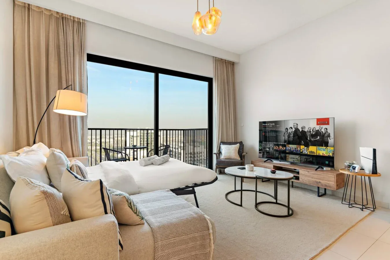 A bright living room with seating, a television, and large glass doors.