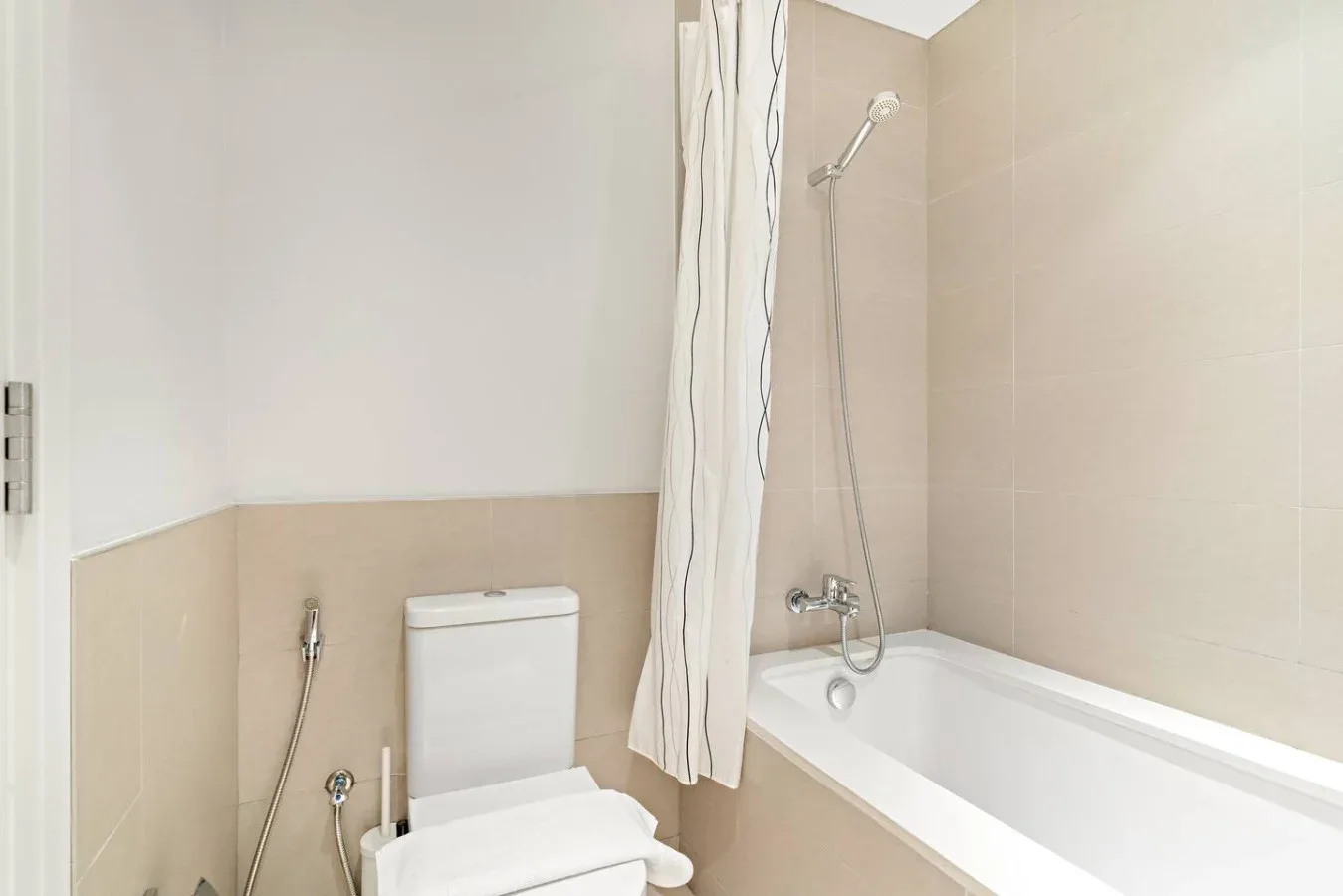 A bathroom with a bathtub, shower, and toilet.