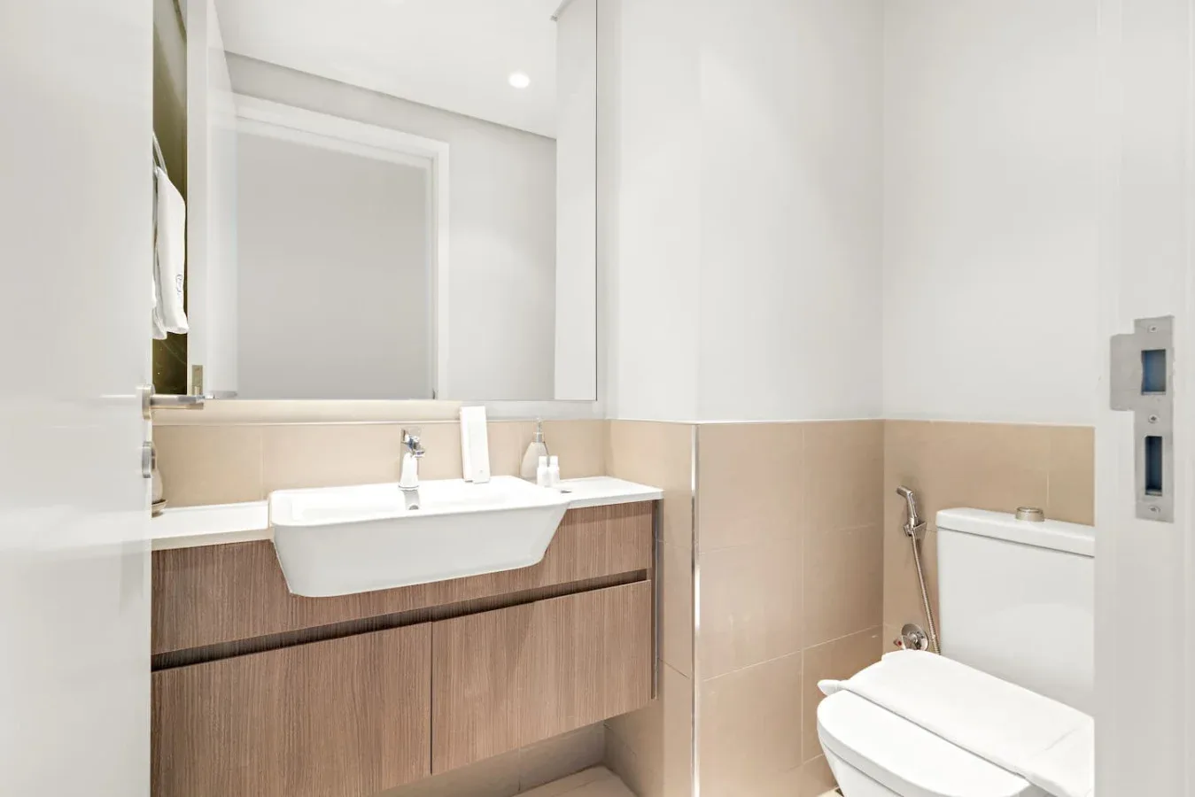 A bright bathroom with a wide sink vanity and a toilet.